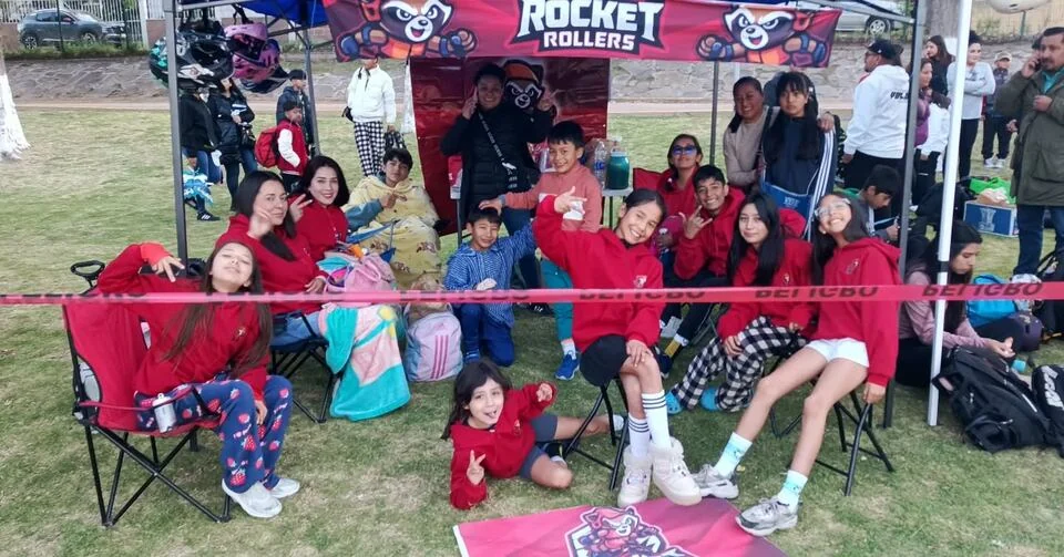 Niñas, niños y familias reunidos bajo la carpa Rocket Rollers.