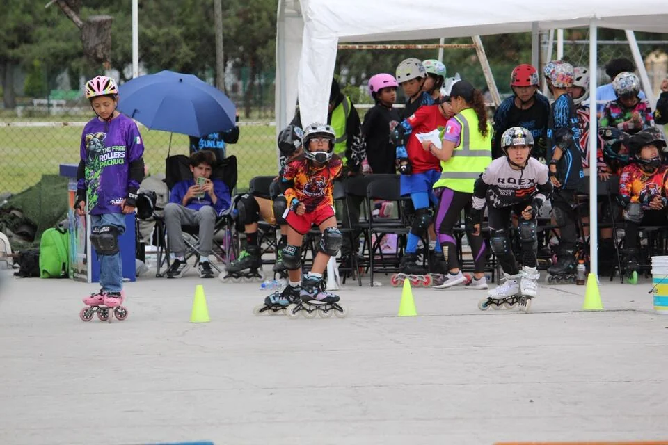 Patinadores esperan y comparten la zona de conos junto a la pista.