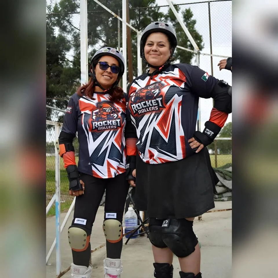 Dos patinadoras adultas del club con uniforme y equipo de protección.